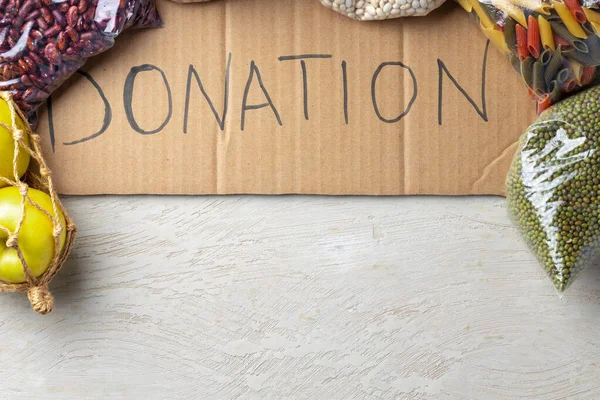 Food donations on the table. Text Donation. — Stock Photo, Image