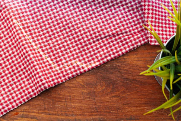 Červený kostkovaný ubrousek nebo ubrus na dřevěném stole — Stock fotografie