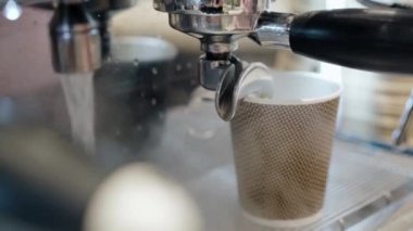 Barista profesyonel kahve makinesiyle kahve hazırlıyor.