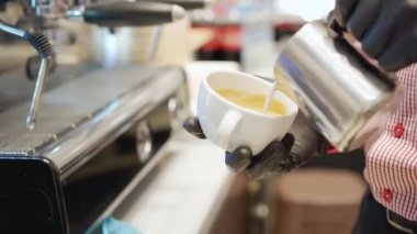 Barista profesyonel kahve makinesiyle kahve hazırlıyor.