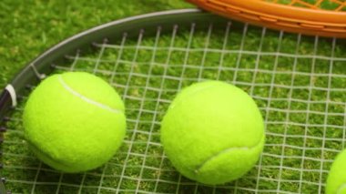 Yeşil çimlerde tenis topları ve raket yakın plan