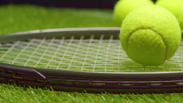 Pelotas de tenis y raqueta sobre hierba verde fondo de cerca — Vídeos de Stock