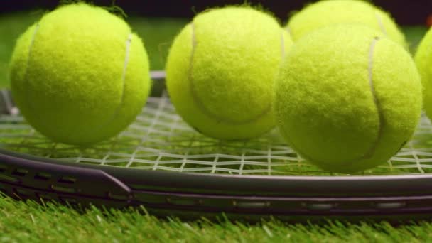 Palle da tennis e racchetta su sfondo verde erba da vicino — Video Stock