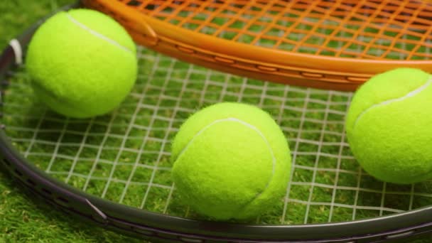 テニスボールとラケットで緑の芝生の背景をクローズアップ — ストック動画