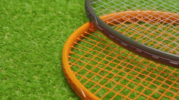 Twee tennis rackets liggen op gras achtergrond close-up — Stockvideo