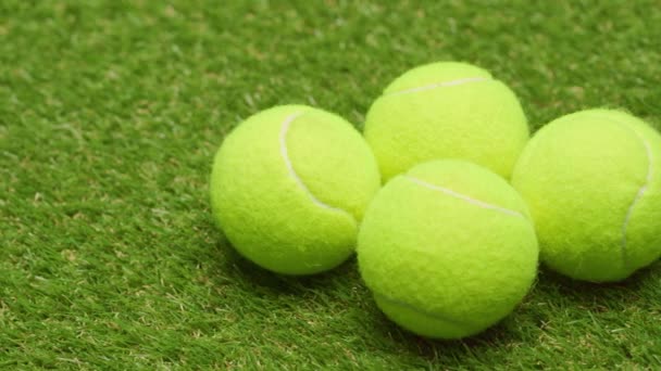 Grupo de pelotas de tenis en el fondo de hierba de cerca — Vídeos de Stock
