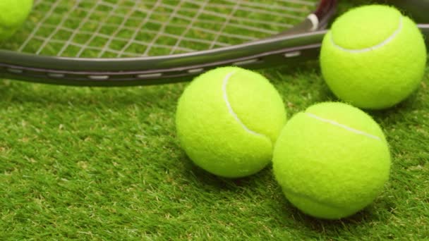 Tennis bollar och racket på grönt gräs bakgrund närbild — Stockvideo