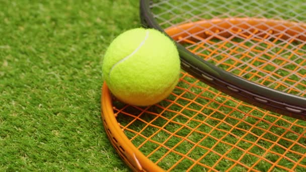 Piłki tenisowe i rakieta na zielonym tle trawy zbliżyć — Wideo stockowe