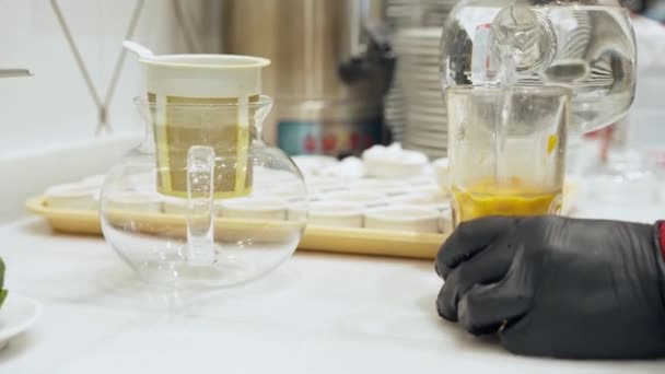 Barista preparar mar buckthorn bebida chá em vidro bule de perto — Vídeo de Stock