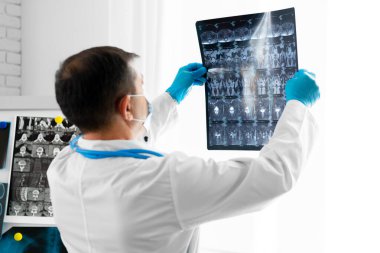 Maskeli kıdemli doktor hastanede kafa MR 'ı çekiyor.
