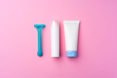 Pembe arka plan görünümünde tıraş jeli ve tek kullanımlık tıraş makinesi.