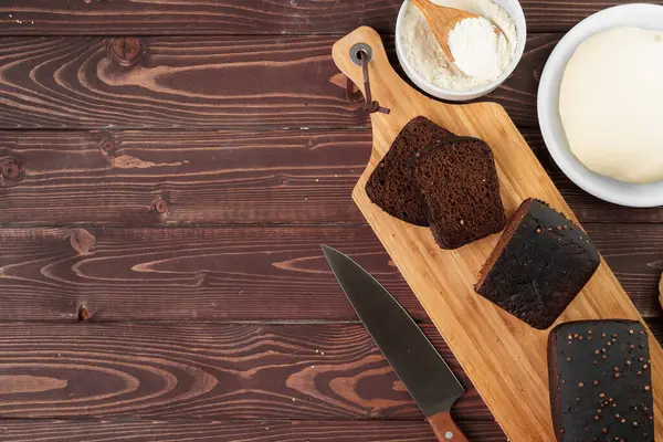 Kahverengi ahşap zemin üzerinde dilimlenmiş çavdar ekmeği — Stok fotoğraf