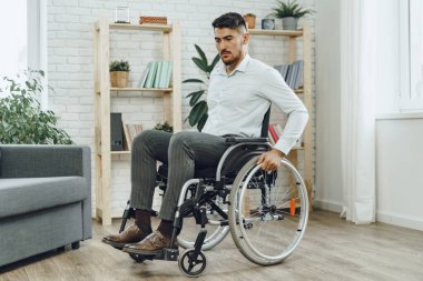 Resmi olarak tekerlekli sandalyede oturan engelli bir adamın portresi.