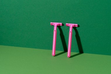 Yeşil arka planda tek kullanımlık jilet, stüdyo çekimi.