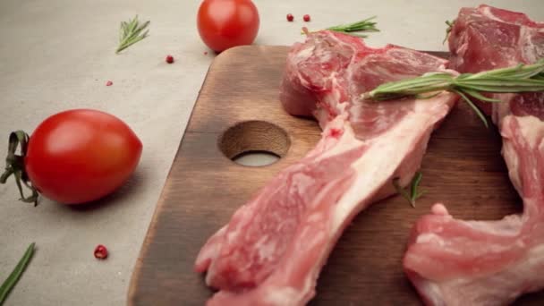 Rauwe lamsvlees rekken op houten plank met specerijen en rozemarijn — Stockvideo