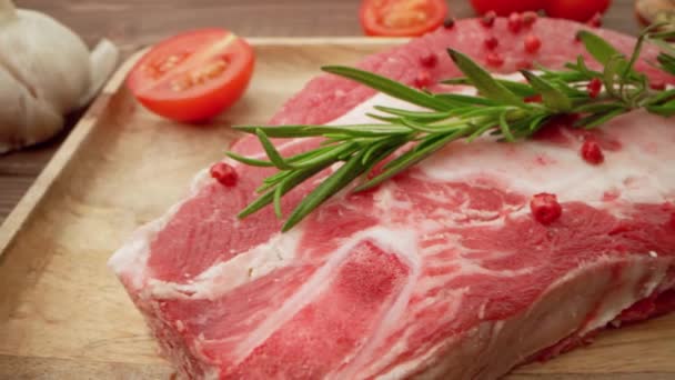 Bistecche fresche di carne cruda su tavola di legno con spezie da vicino — Video Stock