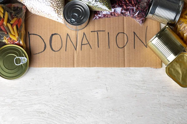 Food donations on the table. Text Donation. — Stock Photo, Image