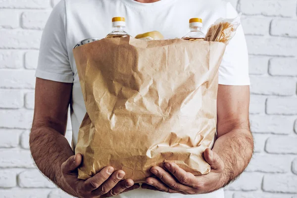 Repartidor con mascarilla y guantes. Entrega de alimentos, concepto de compras en línea mientras que la pandemia coronavirus — Foto de Stock