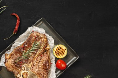 Siyah masada ızgara biftek manzarası var.