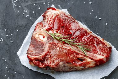 Esmer arka planda baharatlı çiğ biftek.