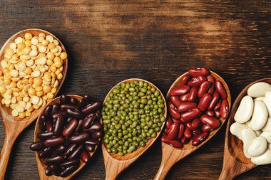 Masanın üzerinde kuru fasulye ve tahta kaşıklar.