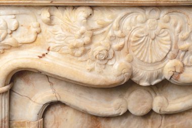 Taş lüks şöminenin üzerine oyulmuş desenler. Yakın çekim.