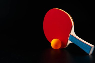 Koyu arkaplanda kırmızı ping pong raketi