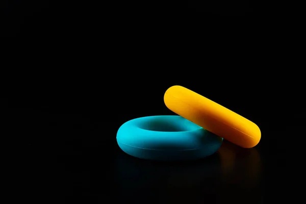 Two round rubber expander on black background — Stock Photo, Image
