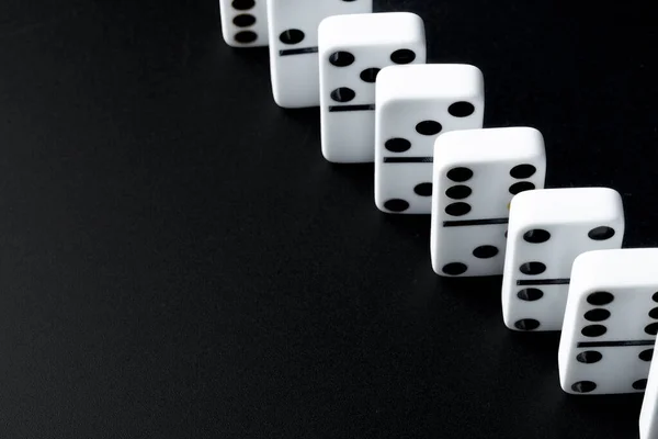 Domino pieces put in a row on black background — Stock Photo, Image