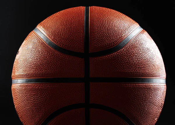 Bola de basquete perto no fundo preto escuro — Fotografia de Stock