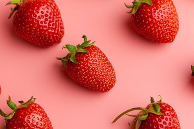 Pembe arka planda çilek. Yaratıcı gıda konsepti.