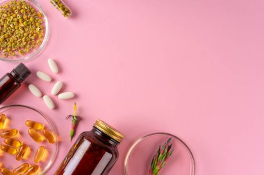 Bitki ve bitkisel beslenme takviyeleri pembe arka planda üst görünüm