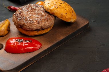 Tahtada ekmek olan ızgara burger pirzolası.