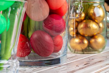 Cam bir kavanozda çiçekli canlı Paskalya yumurtaları. Yakından kesilmiş görüntü.