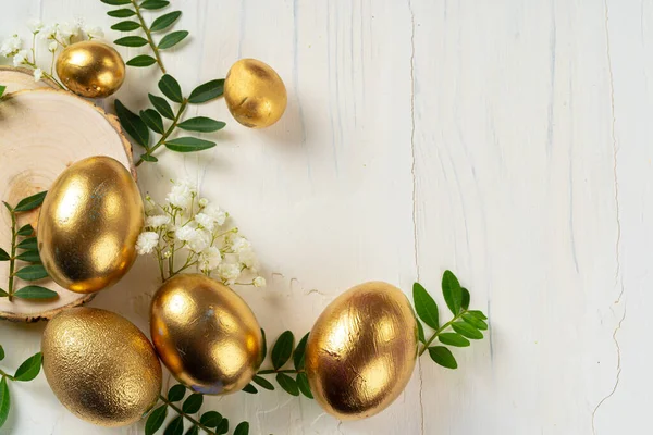 Uova dipinte dorate lucide con rami floreali — Foto Stock