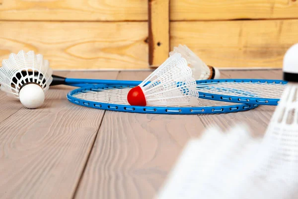Equipo de bádminton. Raquetas y lanzadera sobre mesa de madera — Foto de Stock