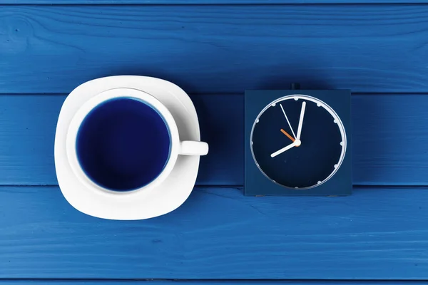 Bovenaanzicht van een kopje koffie op schotel op klassieke blauwe achtergrond — Stockfoto