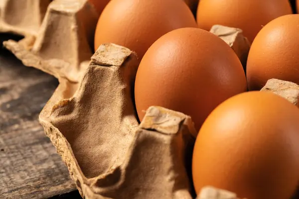Huevos de pollo en caja sobre mesa de madera. — Foto de Stock