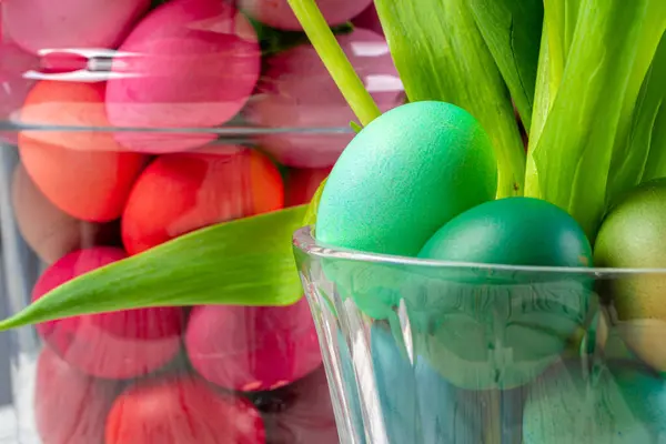 Ovos de Páscoa vibrantes com flores em um frasco de vidro de perto, imagem cortada — Fotografia de Stock