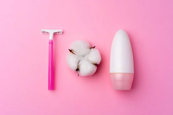 ピンク使い捨てカミソリとピンクの背景に綿の花 — ストック写真