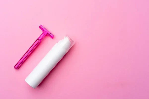 Гель для бритья и одноразовая бритва на розовом фоне вид сверху — стоковое фото