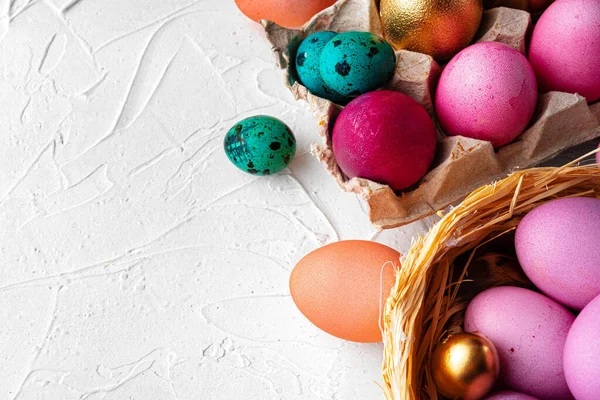 Composição de ovos de Páscoa brilhantemente pintada em fundo branco em relevo — Fotografia de Stock