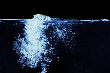 Akvaryumda su sıçraması siyah arkaplanda izole edilmiş.