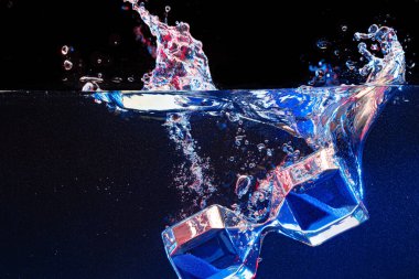 Kum saati siyah zemine karşı suya dalıyor