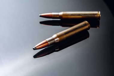Siyah parlak arkaplanda tüfek mermileri veya kartuşlar