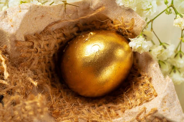 Glossy golden painted eggs with floral branches — Stock Photo, Image