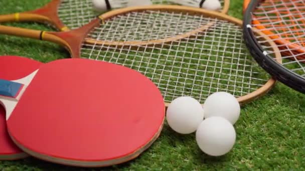 Sportuitrusting, rackets en ballen op gras achtergrond — Stockvideo