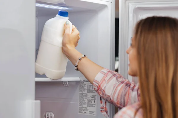 Mujer tomando comida de un frigorífico de cerca — Foto de Stock