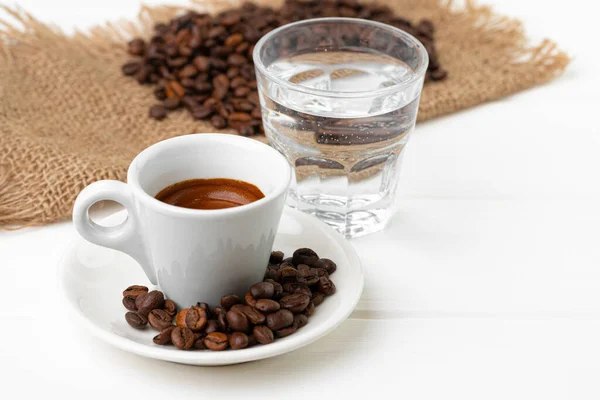 Tasse Espresso mit Glas Wasser auf weißem Tisch — Stockfoto