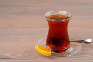 Cam bardakta Türk çayı ve ahşap masada bir parça limon